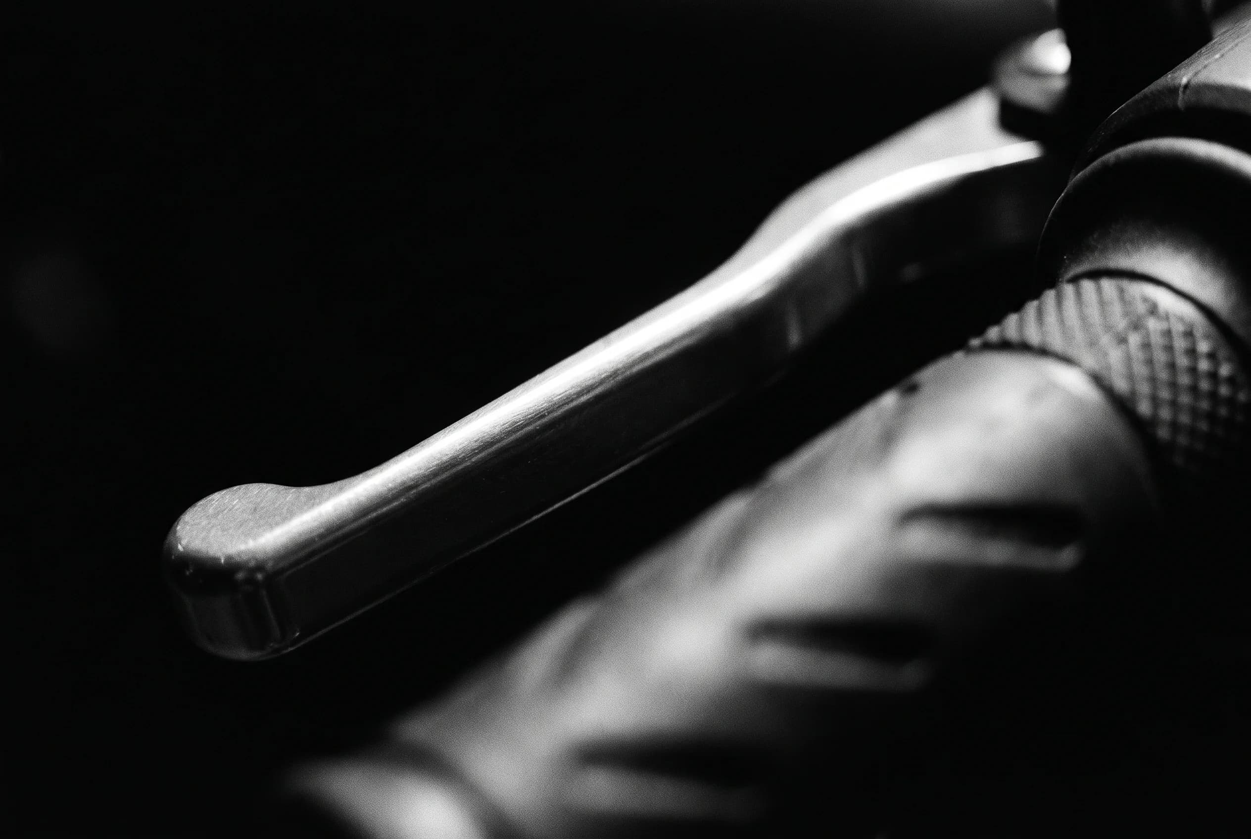 A motorcycle brake lever traced by hard black-and-white light