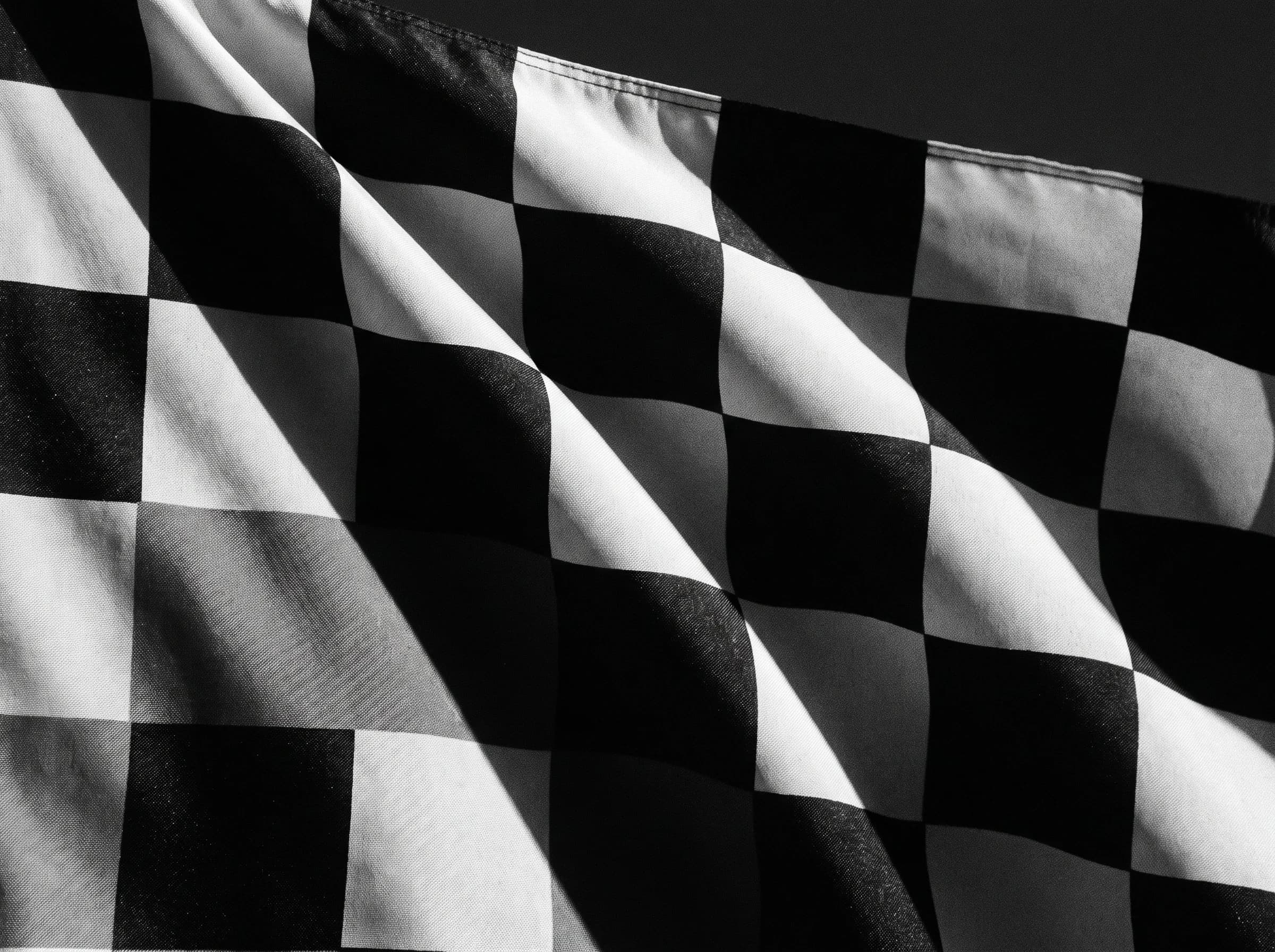 A checkered fabric form in hard black-and-white light